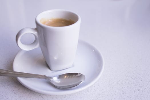Cafeteria table with white cup of coffee