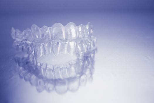 Plastic dental orthodontics on colored background. No people
