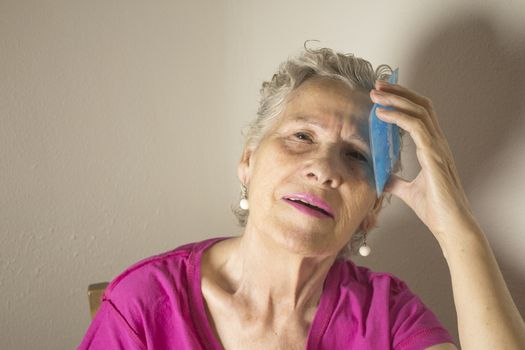 Ice pack for headache in older woman