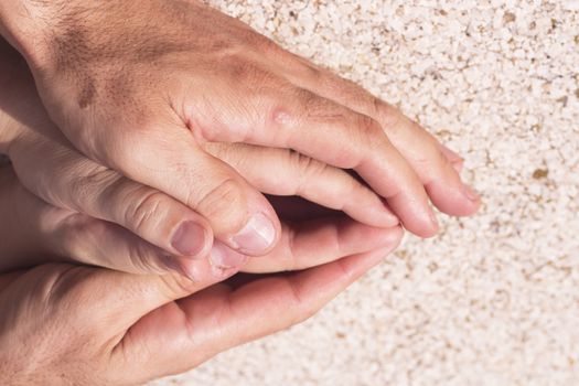 Hands of man and woman intertwined in affectionate attitude