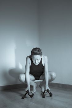Woman initiating crow movement in yoga