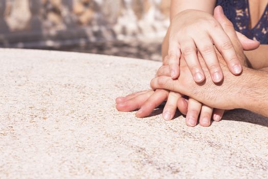 Hands of man and woman intertwined in affectionate attitude