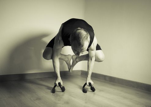Man performing crow motion in yoga
