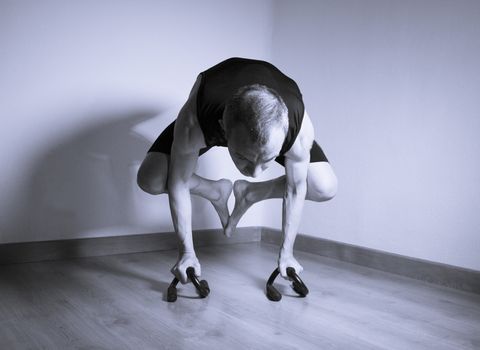 Man performing crow motion in yoga
