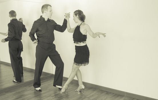 Couple of dancers with attractive latin costumes dancing salsa and different latin caribbean rhythms