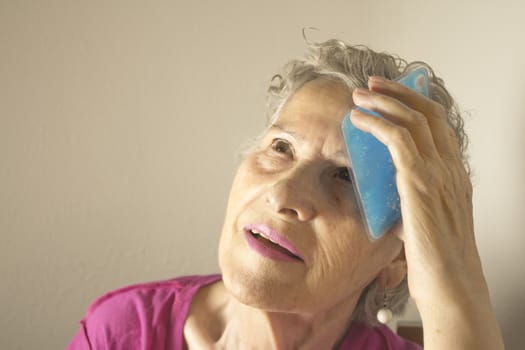 Ice pack for headache in older woman
