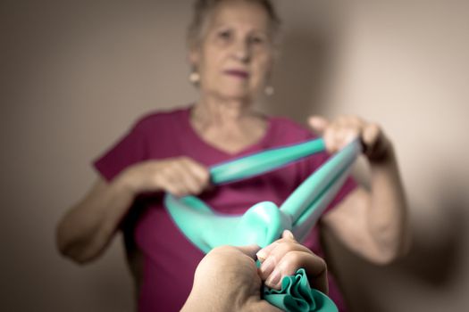 Rehabilitation exercises for older women with elastic band