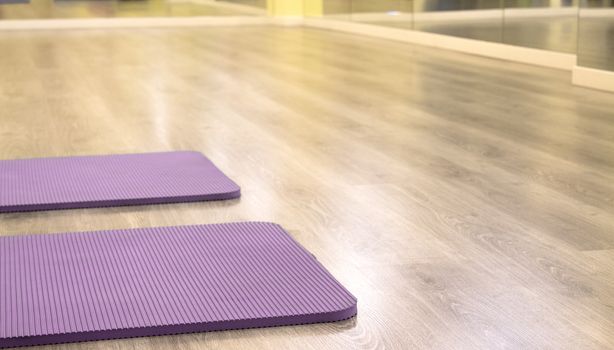 Yoga mat on wooden floor to perform meditation exercises