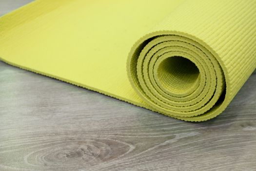 Yoga mat on wooden floor to perform meditation exercises