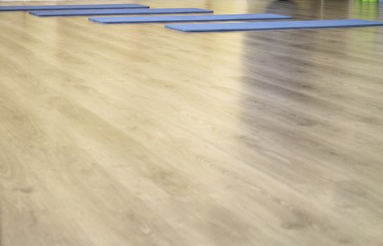 Yoga mat on wooden floor to perform meditation exercises