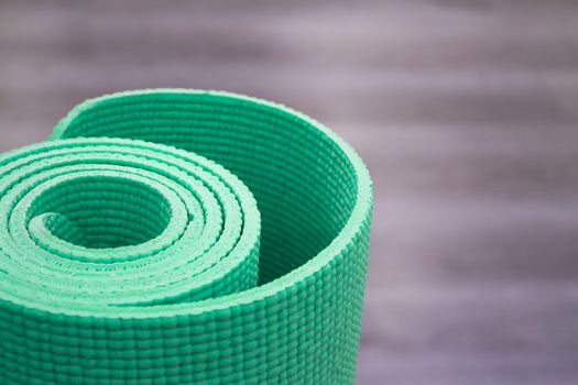 Yoga mat on wooden floor to perform meditation exercises