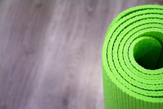 Yoga mat on wooden floor to perform meditation exercises
