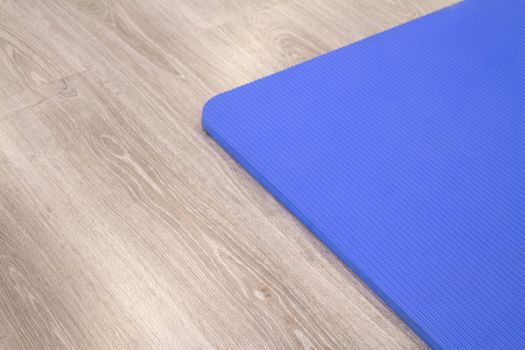 Yoga mat on wooden floor to perform meditation exercises