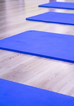 Yoga mat on wooden floor to perform meditation exercises