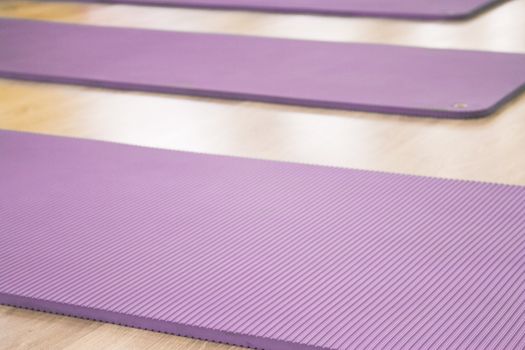 Yoga mat on wooden floor to perform meditation exercises