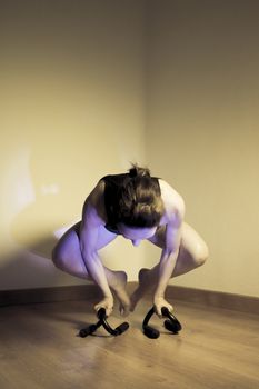 Woman initiating crow movement in yoga