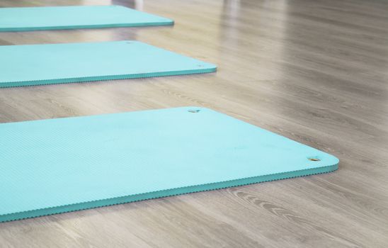 Yoga mat on wooden floor to perform meditation exercises