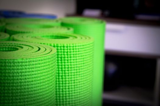 Yoga mat on wooden floor to perform meditation exercises