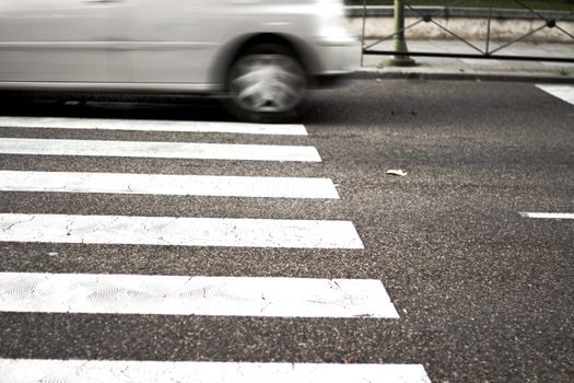 Pedestrian crossing with unfocused car in the background. No people