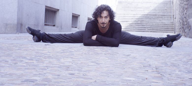 Male dancer in ballet pose. Street background