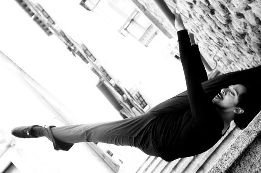 Male dancer doing a classic ballet pirouette. Urban background