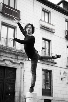 Male dancer performing pirouette. Urban background