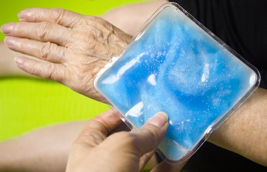 Old woman with ice pack for muscle aches