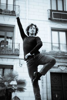 Male dancer performing pirouette. Urban background