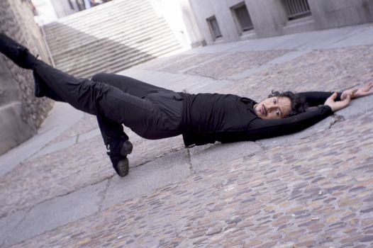 Male dancer in ballet pose. Street background