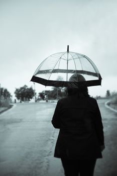 Unrecognizable woman with transparent umbrella in the rain