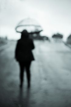 Unrecognizable woman with transparent umbrella in the rain