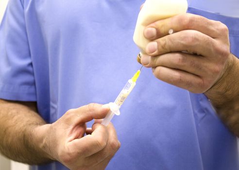 Hands of veterinarian preparing a syringe with medicine