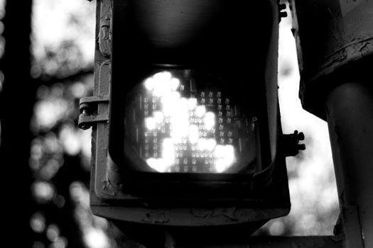 Traffic light with person drawing in green to indicate crossing the road to pedestrians