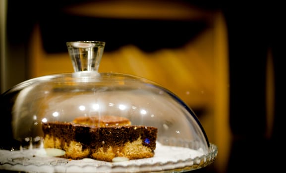 Cake inside a glass bowl in the pastry shop. No people
