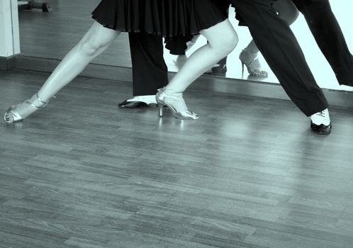 Couple of dancers dancing lindy hop in bright gold and black and white shoes
