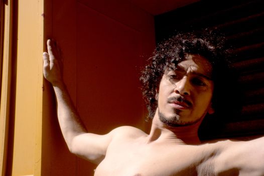 Latin male dancer posing with dancing figures. Urban background