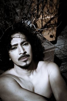 Portrait of latin man with beard and curly black hair. Naked torso