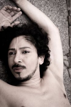 Portrait of latin man with beard and curly black hair. Naked torso