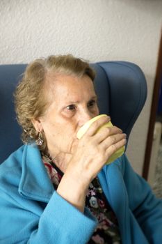 Older woman drinking water from a glass to hydrate