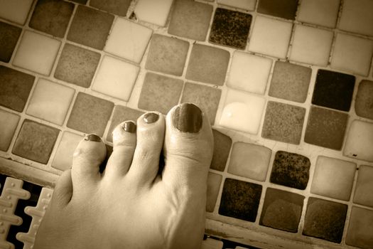 Bare feet of woman with nails painted red. Pool background