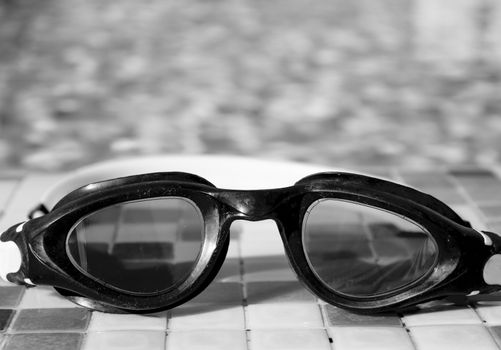 Glasses for diving on the edge of a summer pool. No people