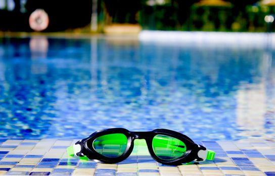 Glasses for diving on the edge of a summer pool. No people
