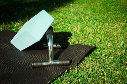 Yoga mat on the grass with yoga block. No people