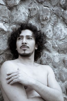 Portrait of man with beard and naked torso. No smile.