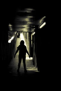 Woman alone and sad in a tunnel. Scene of mystery and desolation