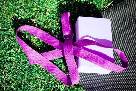 Yoga mat on the grass with yoga block. No people