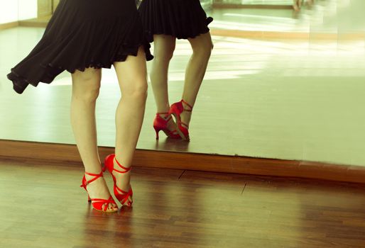Legs of girl with red shoes dancing