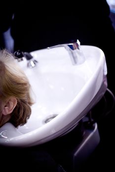 Hairdresser washing the head of a client. Hair not yet wet