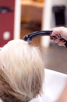 Hairdresser washing the head of a client. Hair not yet wet