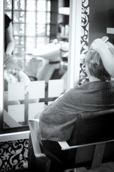 Hairdresser in positive attitude brushing the hair of a client